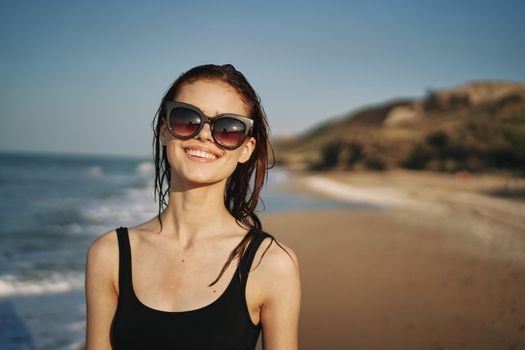 woman walks along the sandy shore in a black swimsuit sun tropics. High quality photo