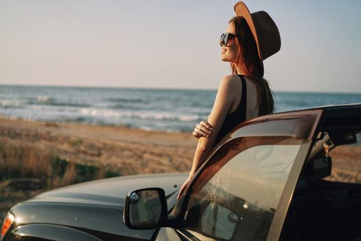 pretty woman in sunglasses near the car on the beach travel lifestyle. High quality photo