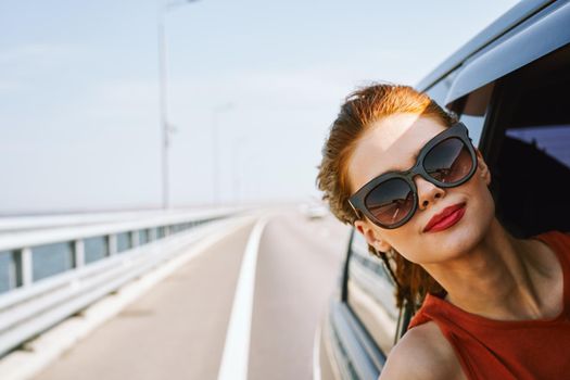 woman looking out of car window wearing sunglasses travel lifestyle. High quality photo