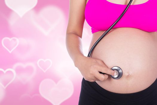 close-up of pregnant woman with stethoscope listening belly to baby on heart backrground
