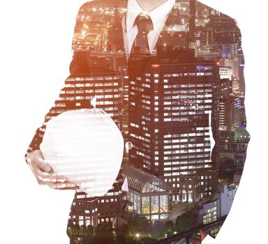Double exposure of engineer with helmet against a city isolated on white background