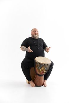 Funn caucasian bearded tattoed man is posing on white background