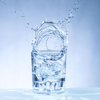 ice cube falling into a glass of water