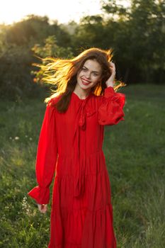 woman in red dress posing nature sun fun. High quality photo