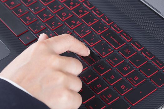 finger pushing enter button on a laptop keyboard