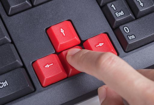 finger pushing arrow button on a keyboard computer