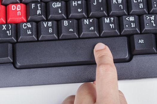 finger pushing space bar button on a keyboard of computer