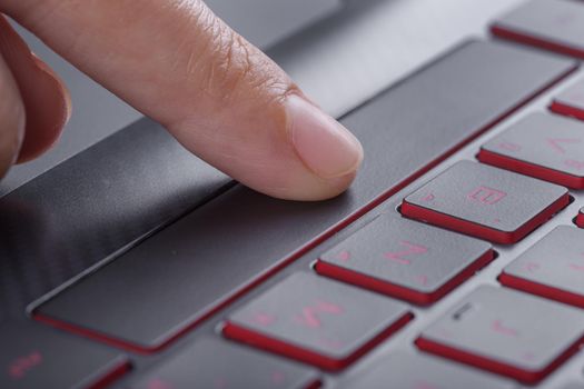 finger pushing space bar button on a laptop keyboard