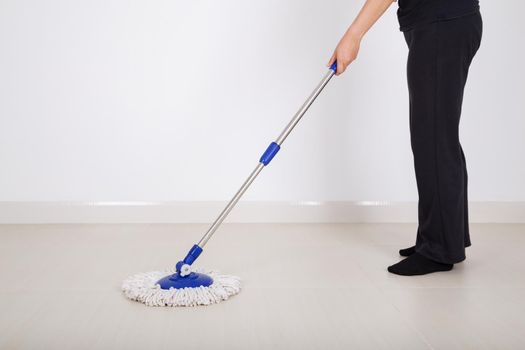 woman legs with mop cleaning floor at home