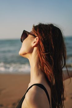 cheerful woman in sunglasses Sandy coast landscape sun. High quality photo