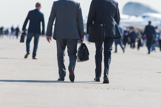 Business people walking down the street talking. Back view