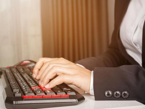 business hands working on computer keyboard with sunlight