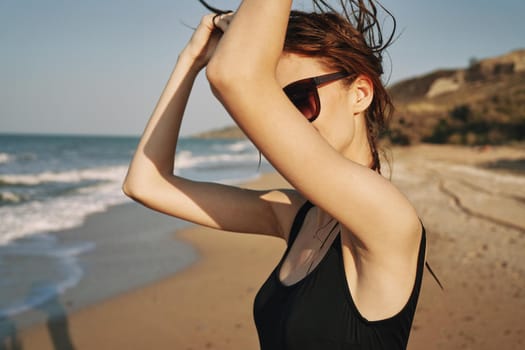 cheerful woman sunglasses posing black swimsuit island. High quality photo