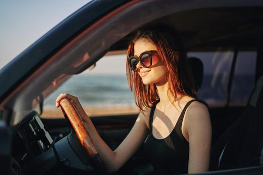 cheerful woman in sunglasses driving a car trip travel. High quality photo