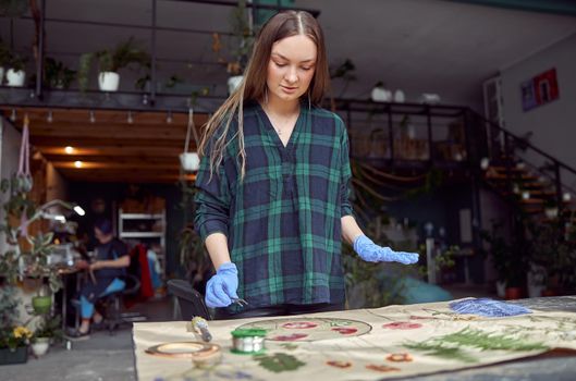 Confident female florist is working with dryed flowers in cozy flower shop