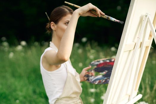 cheerful woman artist painting a picture outdoors creative art. High quality photo