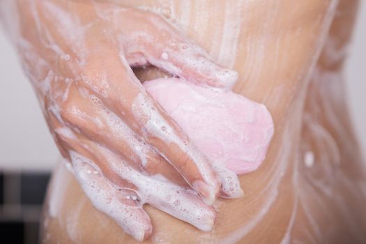 close up of woman washing her body with soap 