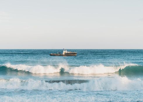 Boat in the sea at windy weather, sea waves with foam