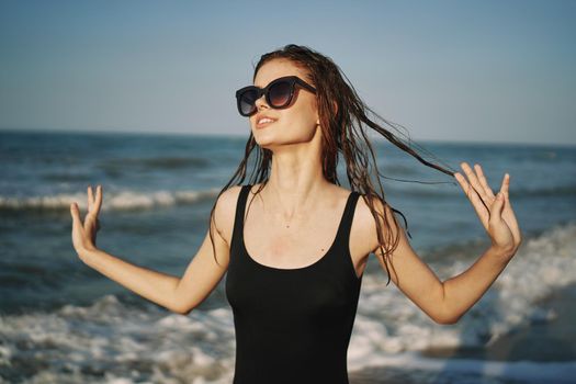 cheerful woman in black swimsuit sunglasses ocean travel. High quality photo