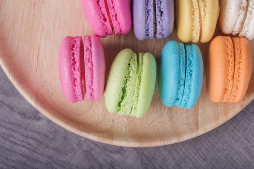 sweet colorful cake macaron or macaroon in plate on wood table