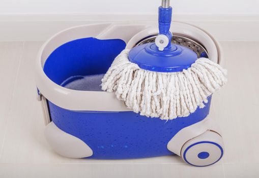 close up of mop and blue bucket for cleaning the floor