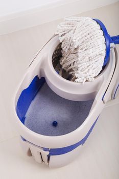 close up of mop and blue bucket for cleaning the floor