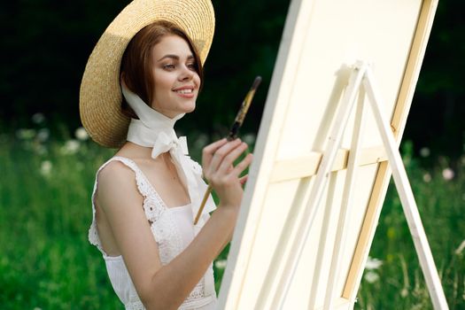 Woman in white dress artist easel painting nature landscape. High quality photo