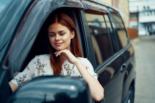 cheerful woman driving a car looks out of the window. High quality photo