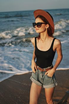 woman walking on the beach hat travel vacation sun. High quality photo