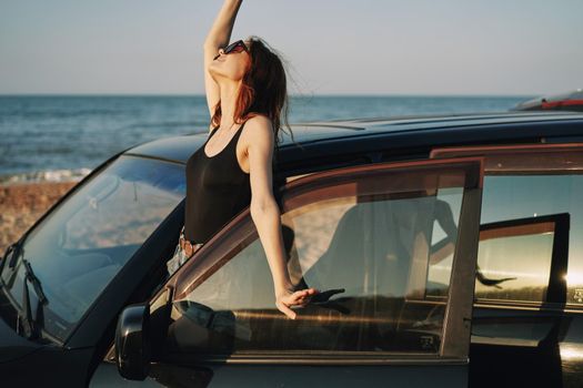 woman on the beach is with a car wearing sunglasses travel. High quality photo