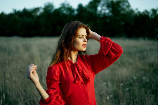 cute red-haired woman in red dress in field nature summer. High quality photo