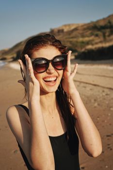 cheerful woman sunglasses posing black swimsuit island. High quality photo