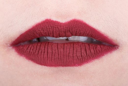 close-up of womans lips with red glossy lipstick