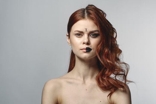 red-haired woman naked shoulders cosmetics horoscope close-up. High quality photo