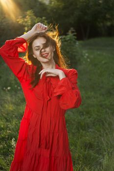 woman in red dress posing nature sun fun. High quality photo