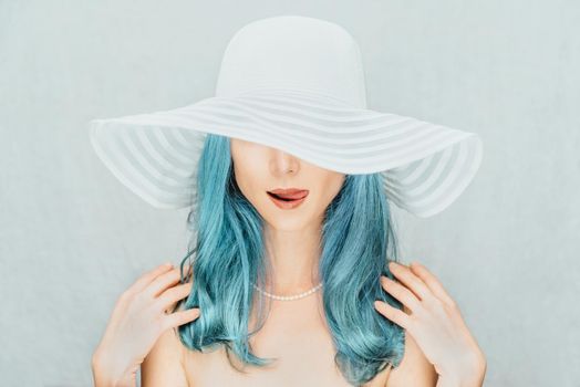 Pretty young woman with blue hair in a hat, fashion and beauty.