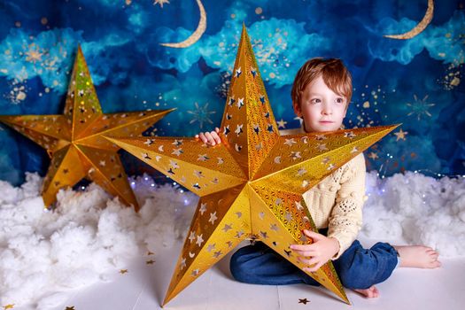 Handsome kid on christmas background holding a christmas star.