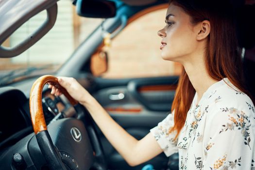 cute red-haired woman driving a car lifestyle trip. High quality photo