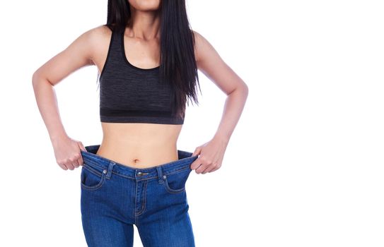 close up of woman show her weight loss and wearing her old jeans isolated on a white background