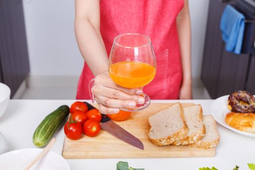 woman with a glass of orange juice in kitchen room at home