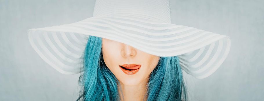 Portrait of pretty young woman with blue hair in a hat, fashion and beauty.