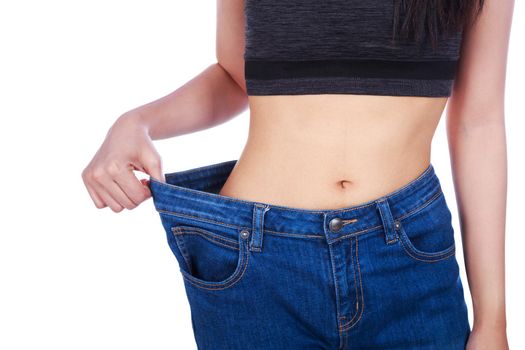 close up of woman show her weight loss and wearing her old jeans isolated on a white background