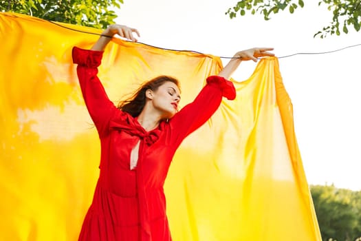 attractive woman in red dress posing yellow background nature. High quality photo