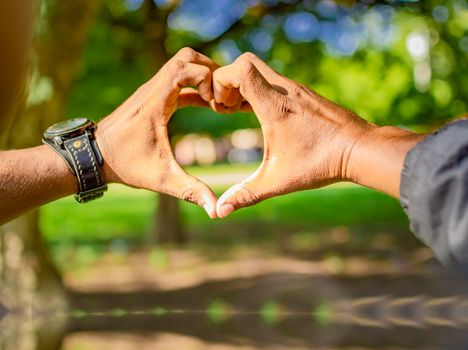 Close up of two hands together in a heart shape, hands together in a heart shape, young man putting fingers together in a heart shape