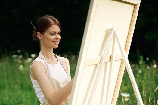 woman artist paints a picture on nature art hobby. High quality photo