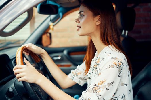 cheerful woman driving a car looks out of the window. High quality photo