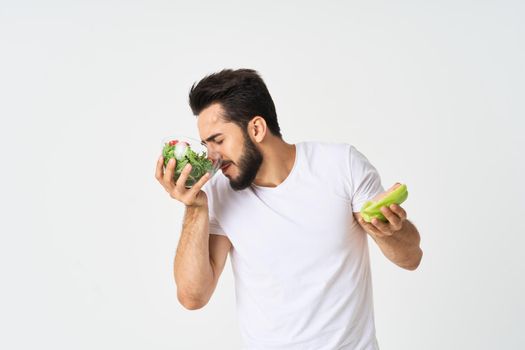 man in white t-shirt plate salad healthy food diet. High quality photo