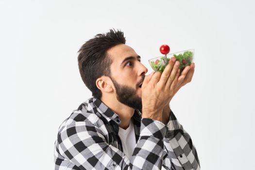 emotional bearded man in plaid shirt plate with salad. High quality photo