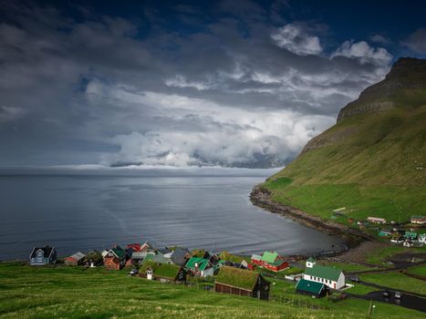 Houses near a lake, several houses near a blue lake with mountains in the background, tents near a beautiful blue lake with many clouds