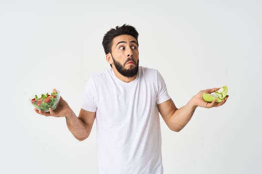 man in white t-shirt plate salad health vegetables. High quality photo